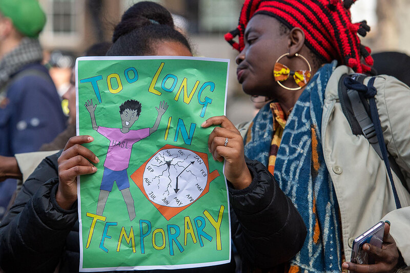 Sign saying “too long in temporary” at a protest about temporary accommodation at Downing Street Sign saying “too long in temporary” at a protest about temporary accommodation at Downing Street
