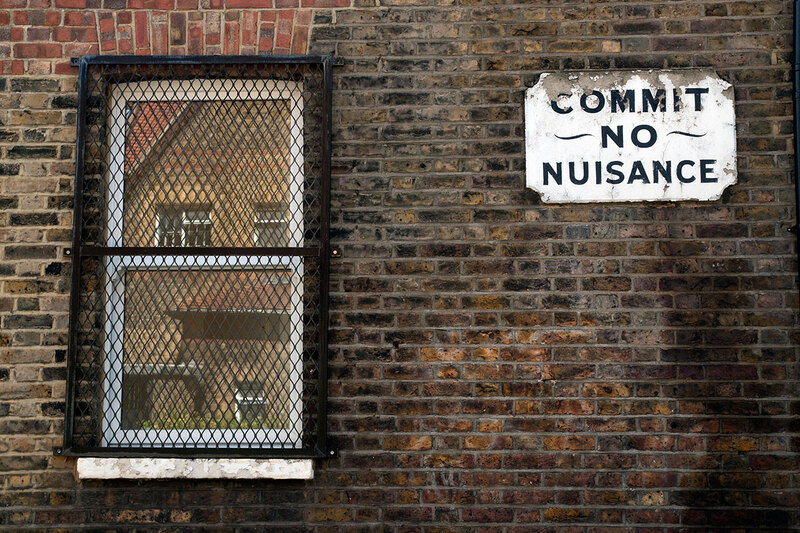 Sign on wall saying “commit no nuisance”