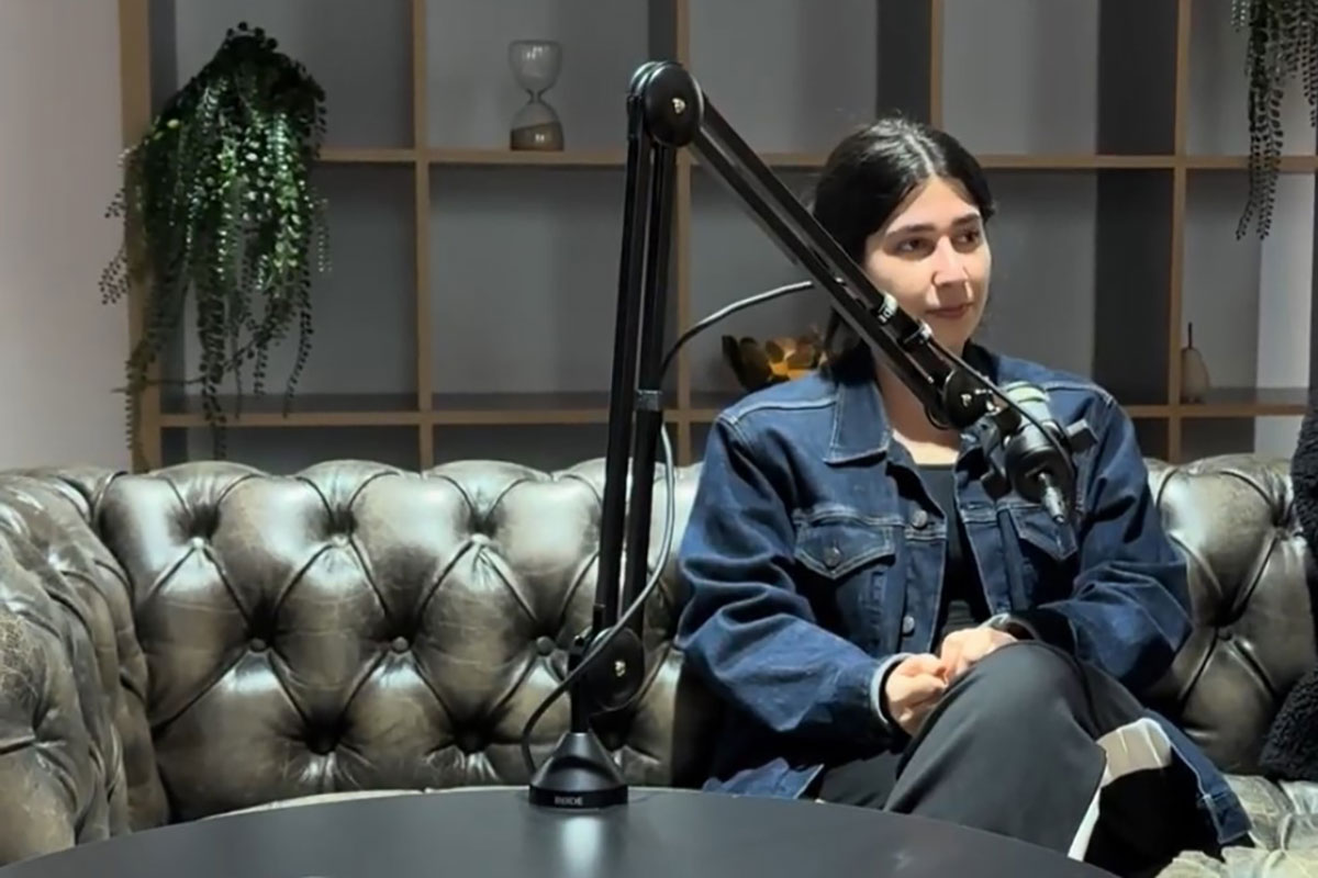 Young woman sitting behind a microphone