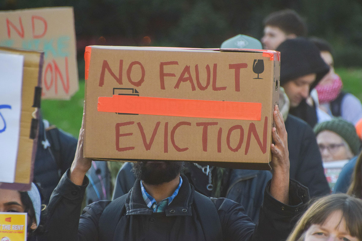 Man holding a placards saying "No fault eviction" at a protest