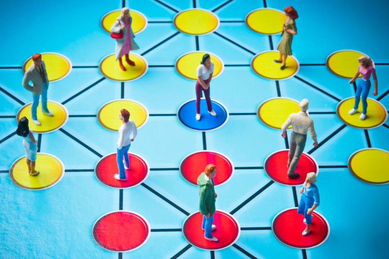 Miniature people standing on connected discs