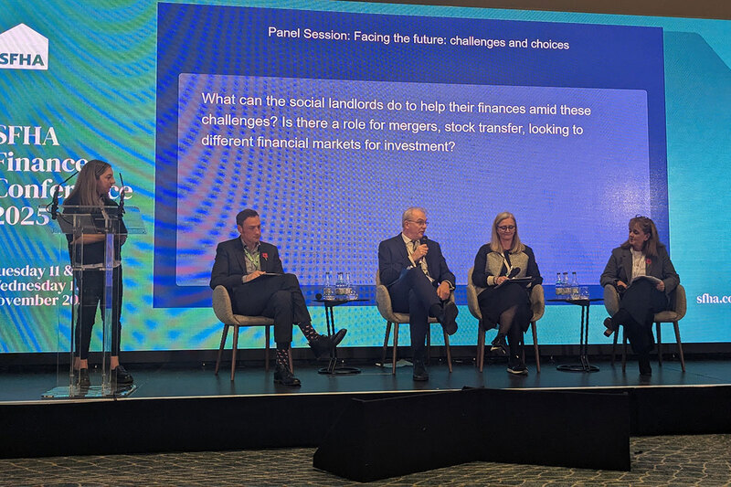 Five speakers at a conference Five speakers at a conference