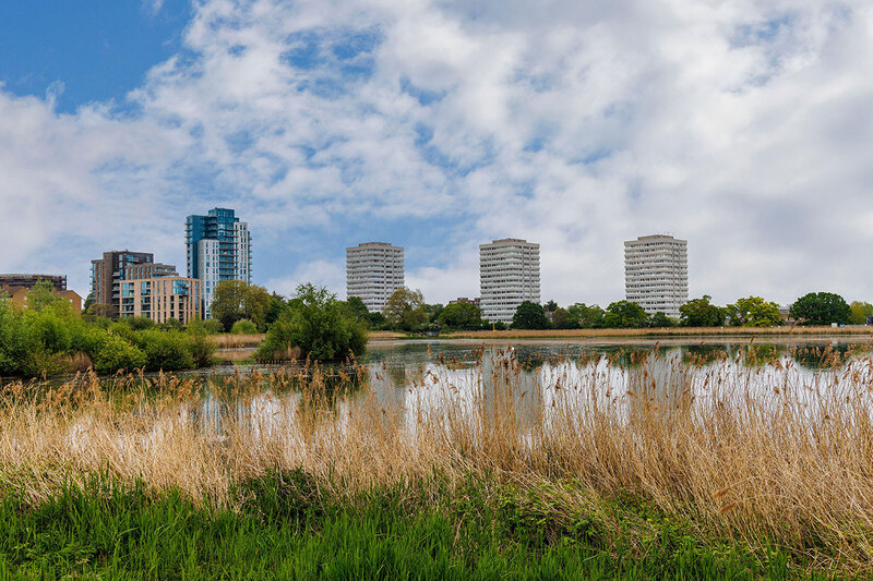 A reservoir and tower blocks in the distance