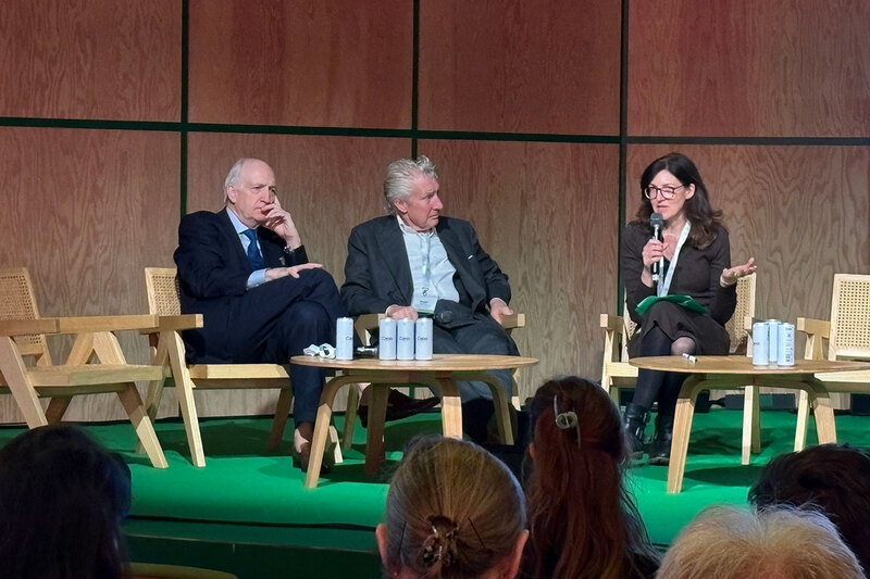 Three people on the panel at a conference Three people on the panel at a conference