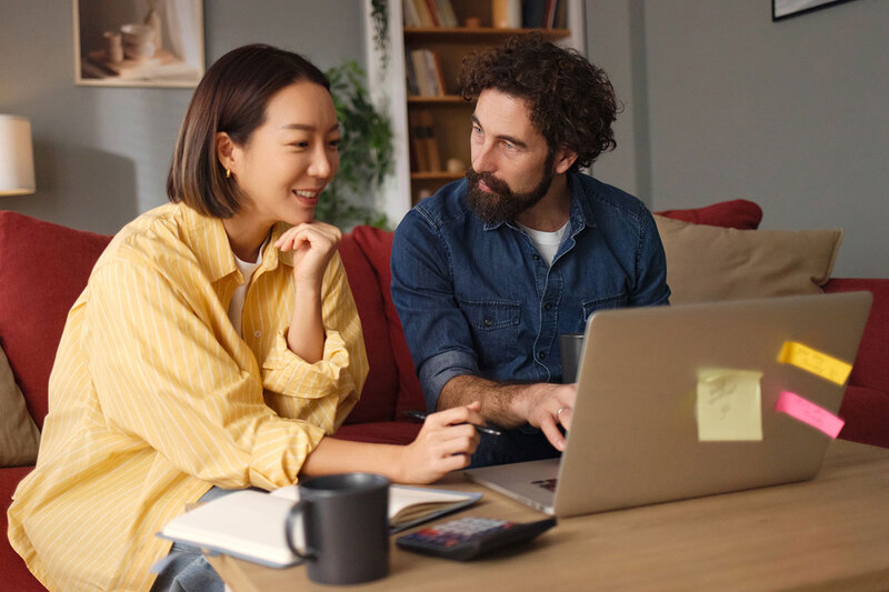 Two people looking at a survey on a laptop